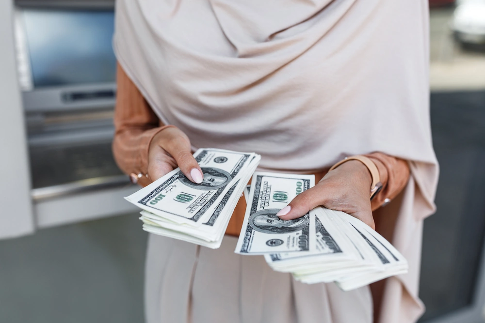 Concept of alimony showing woman holding hundreds of dollars
