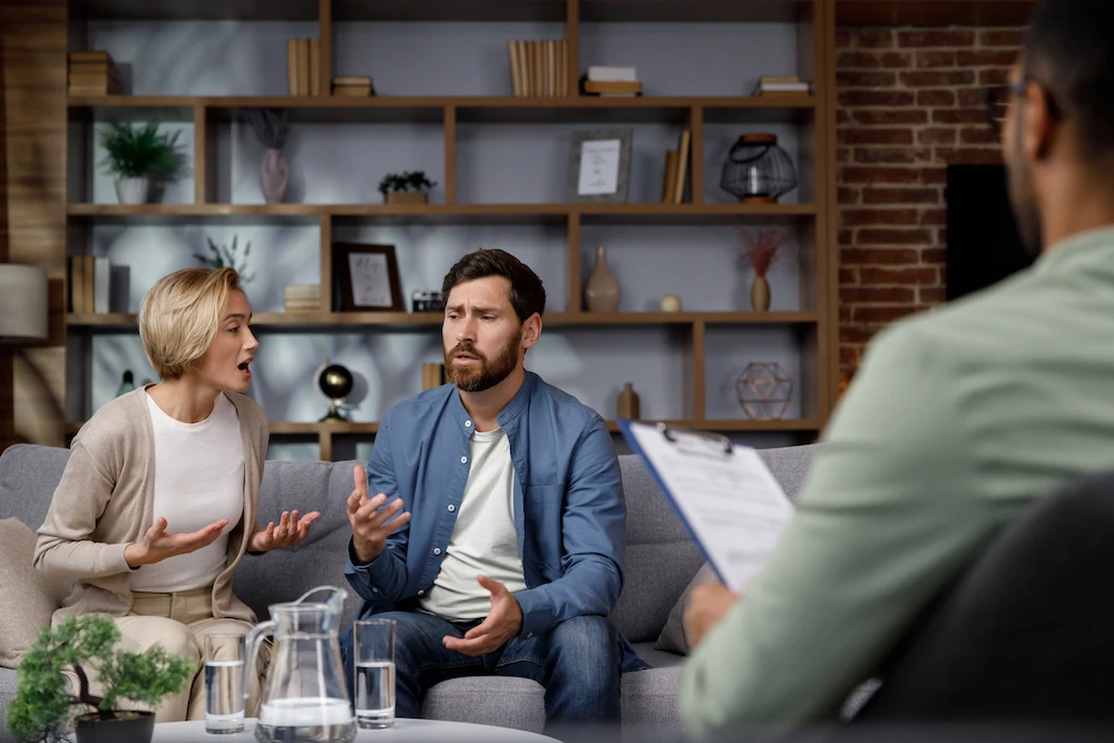 Photo showing married couple together, talking in front of counselor