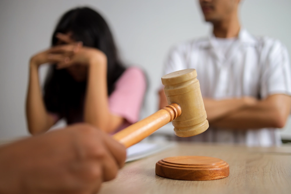 Concept of separation showing gavel in front of unhappy couple