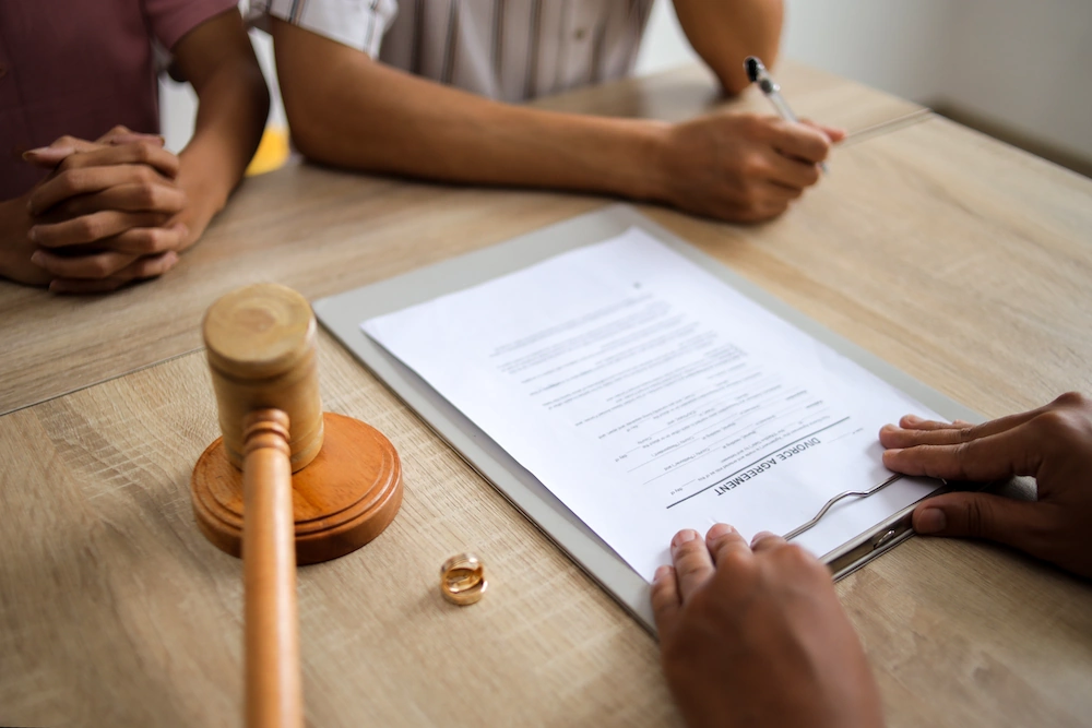 Photo showing divorce document on clipboard in front of people at table